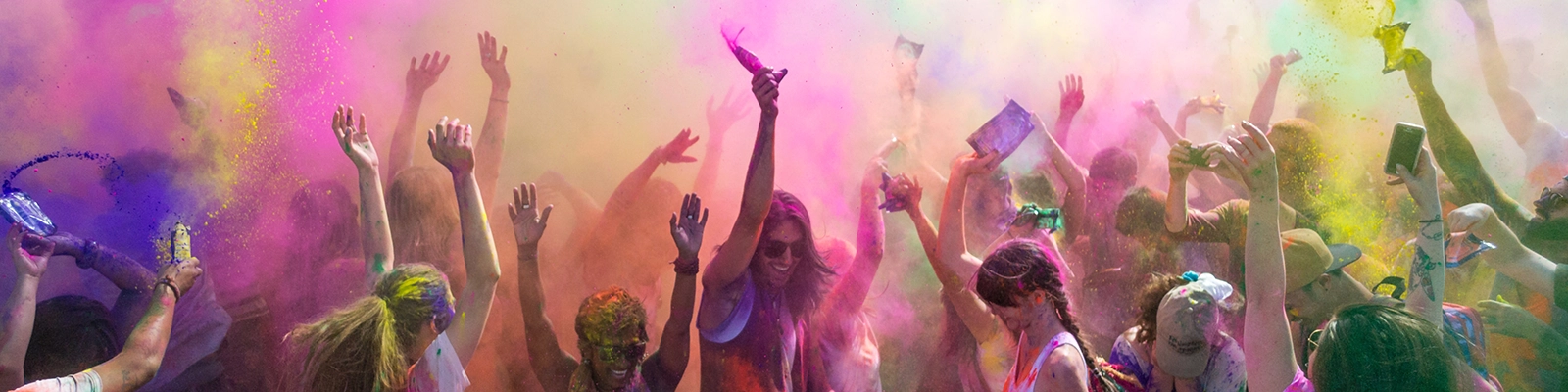 Colorful celebration during the Holi festival, people throwing vibrant powders in the air