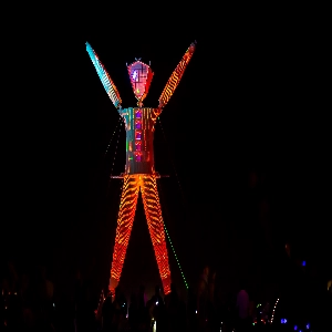 Burning Man Festival, featuring eclectic art installations, unique costumes, and lively participants enjoying the fiery celebration