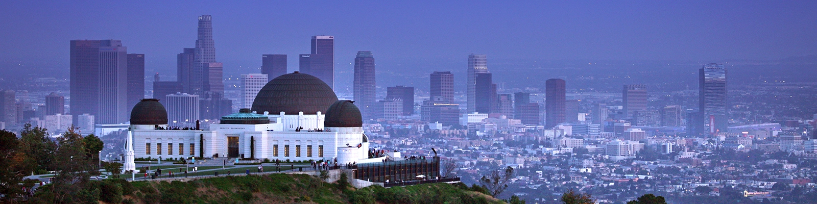 A stunning view of Griffith Observatory, an iconic Los Angeles landmark, situated atop a hill with a beautiful cityscape backdrop