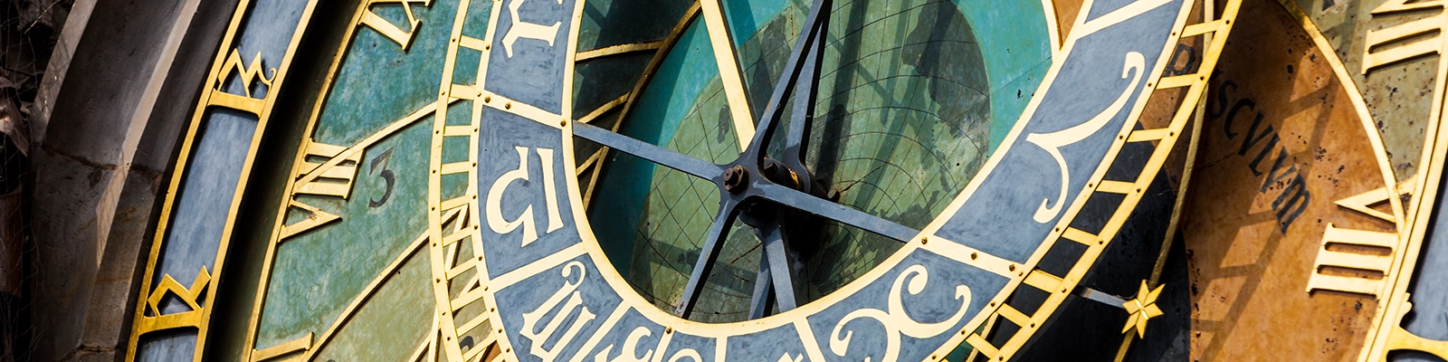 Person examining and learning how to read the Prague Astronomical Clock, a medieval clock tower with detailed astronomical dials and figures.