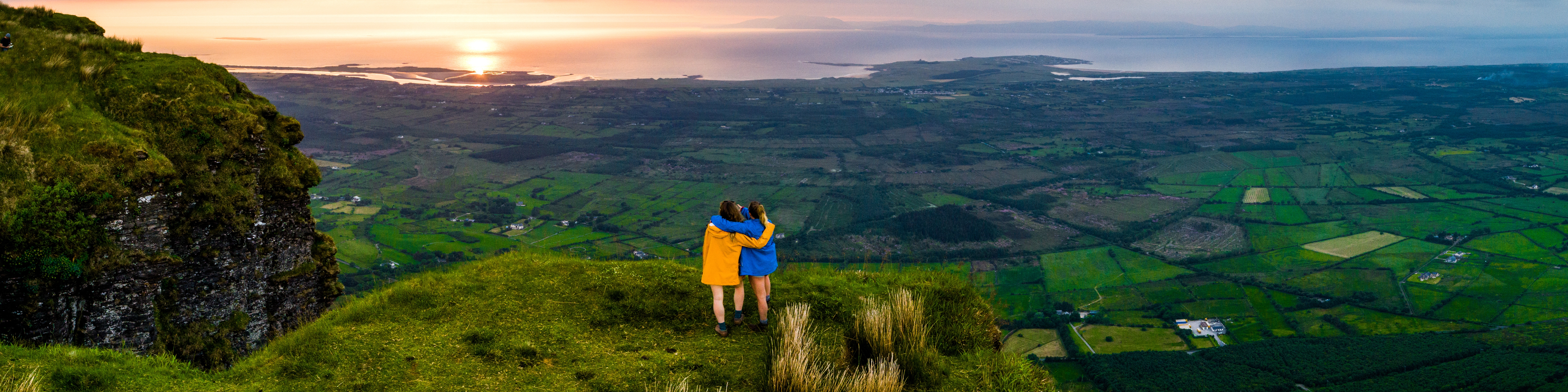 Scenic landscape of Ireland with lush green countryside, rolling hills, and traditional stone buildings