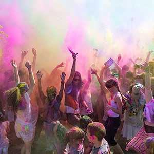 Colorful celebration during the Holi festival, people throwing vibrant powders in the air