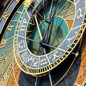 Person examining and learning how to read the Prague Astronomical Clock, a medieval clock tower with detailed astronomical dials and figures.