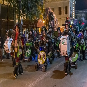 Group of people celebrating Mardi Gras in New Orleans with colorful costumes and masks