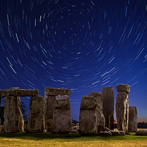 Stonehenge at night with circular star trails.