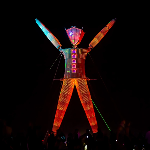 Burning Man Festival, featuring eclectic art installations, unique costumes, and lively participants enjoying the fiery celebration