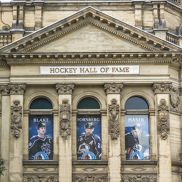 Hockey Hall of Fame entrance with famous players' statues and museum exhibits in the background