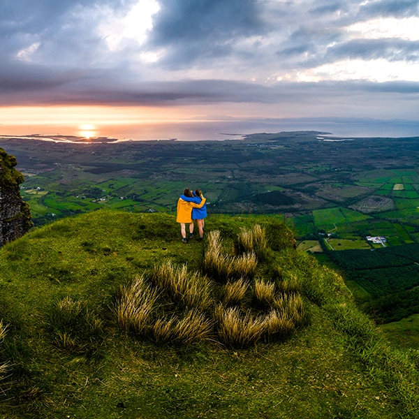 Scenic landscape of Ireland with lush green countryside, rolling hills, and traditional stone buildings
