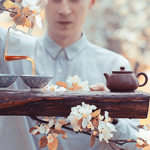 Japanese traditional tea ceremony. Gracefully pouring tea from a teapot into small ceramic cups.